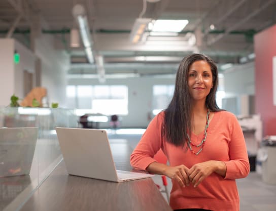 Woman standing next to laptop