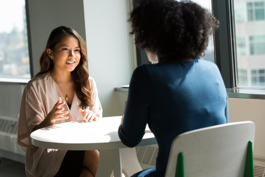 Two women sitting at a table having a discussion